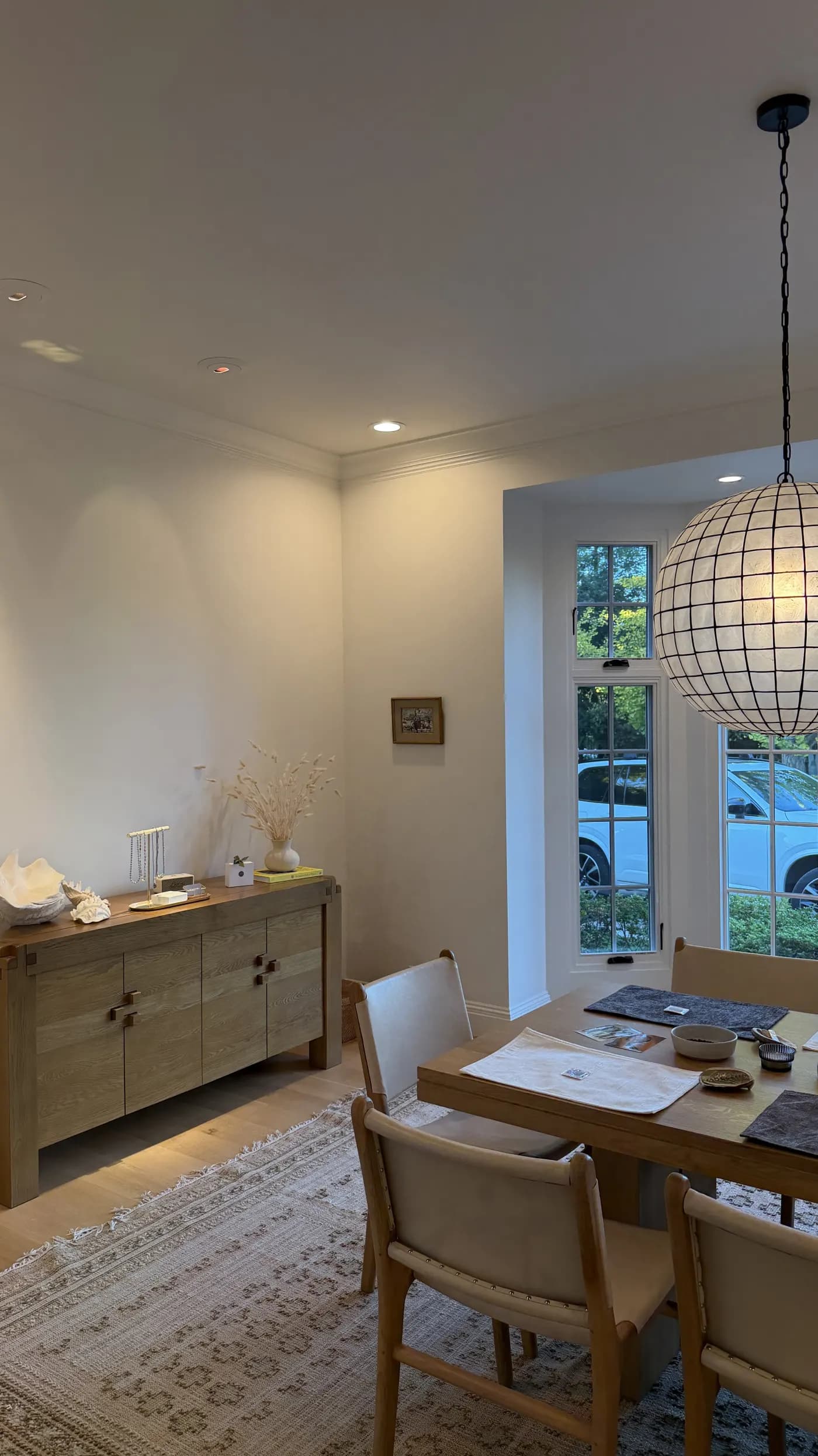 A dining room set for a string & sip, under a capiz pendant