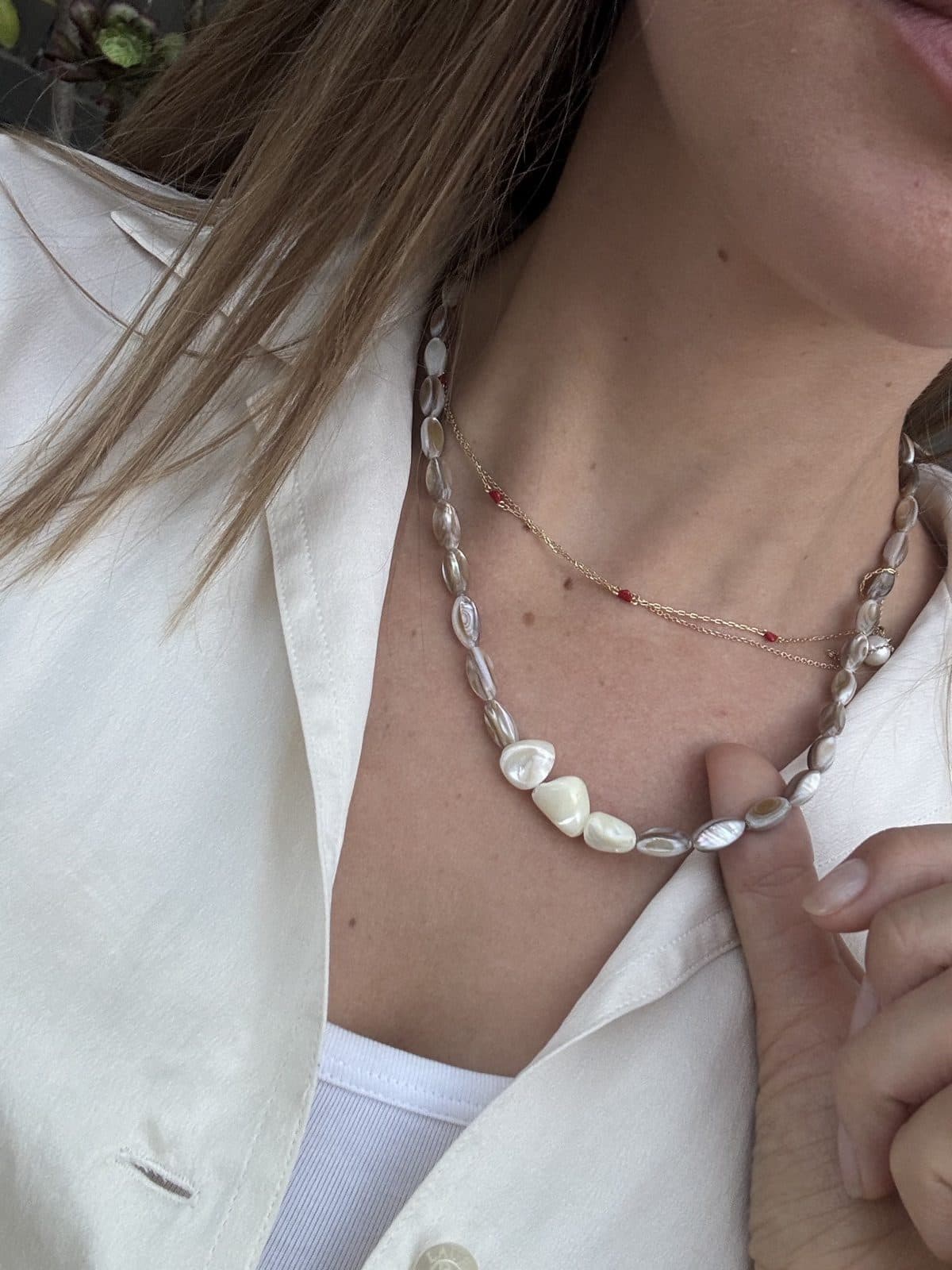 A model wearing layered handmade necklaces